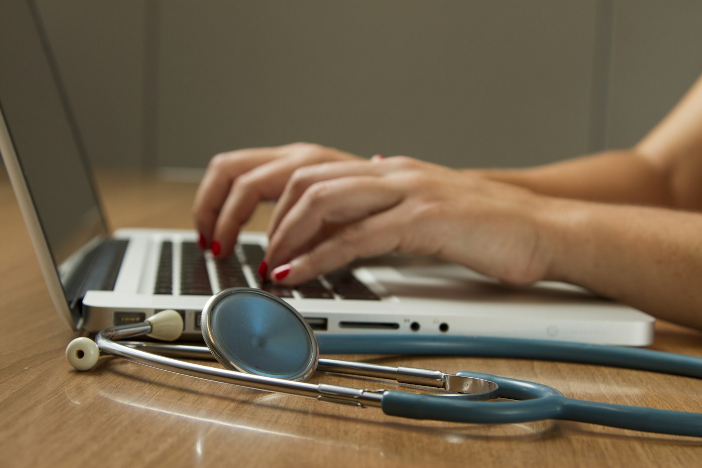A clinician’s desk with a stethoscope and laptop