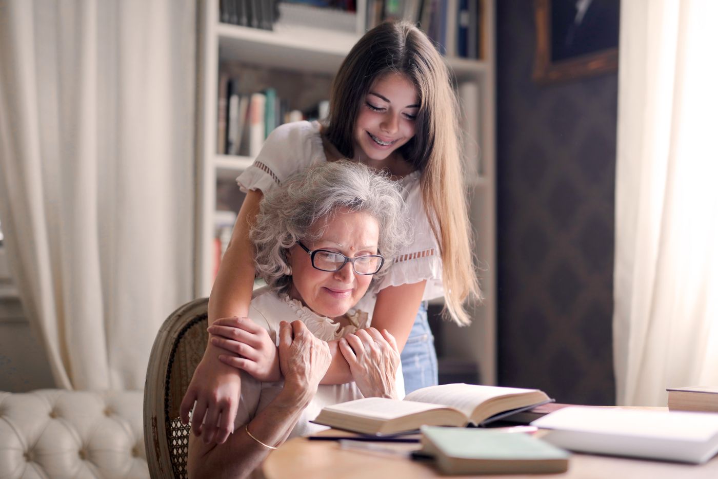 A granddaughter reading with her grandmother